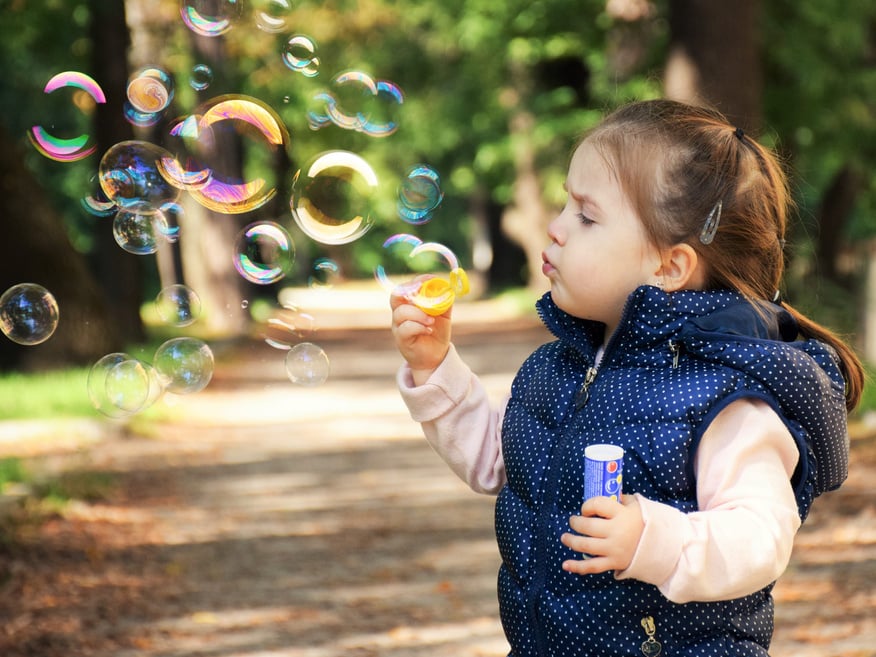 Cute Little Girl Blowing Bubbles