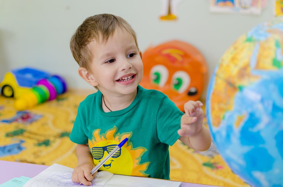 Little Boy Looking at a Globe